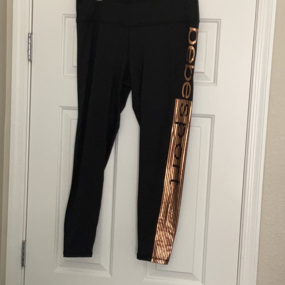 Bebe new black leggings,bronze logo & stripes on left side, Size XL. Perfect!